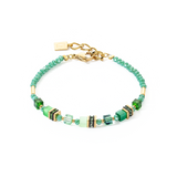 A gold bracelet with bright green stones