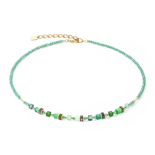 A gold necklace with bright green beads and stones