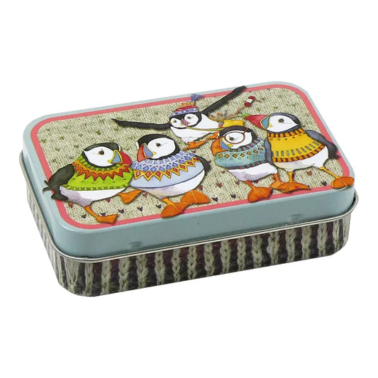 A mini hinged lidded tin covered in illustrations of puffin birds in woolly jumpers