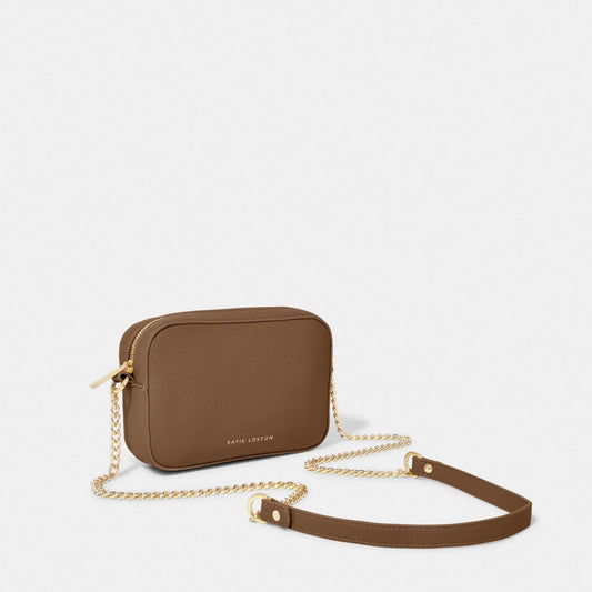 A light brown camera bag with gold chain detail on the strap, textured leather and a zip top