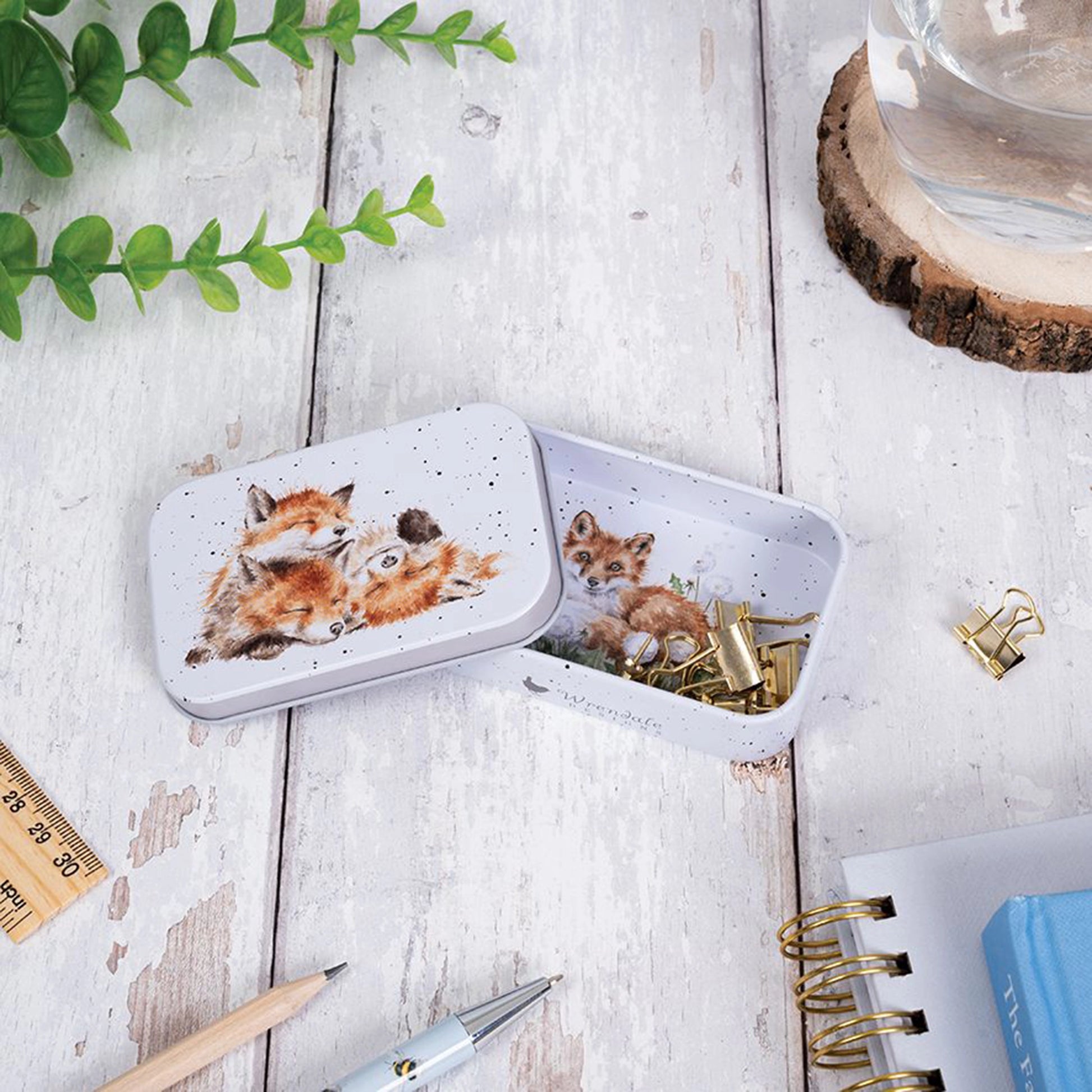 Mini tin fully illustrated with artwork of foxes by Hannah Dale lifestyle