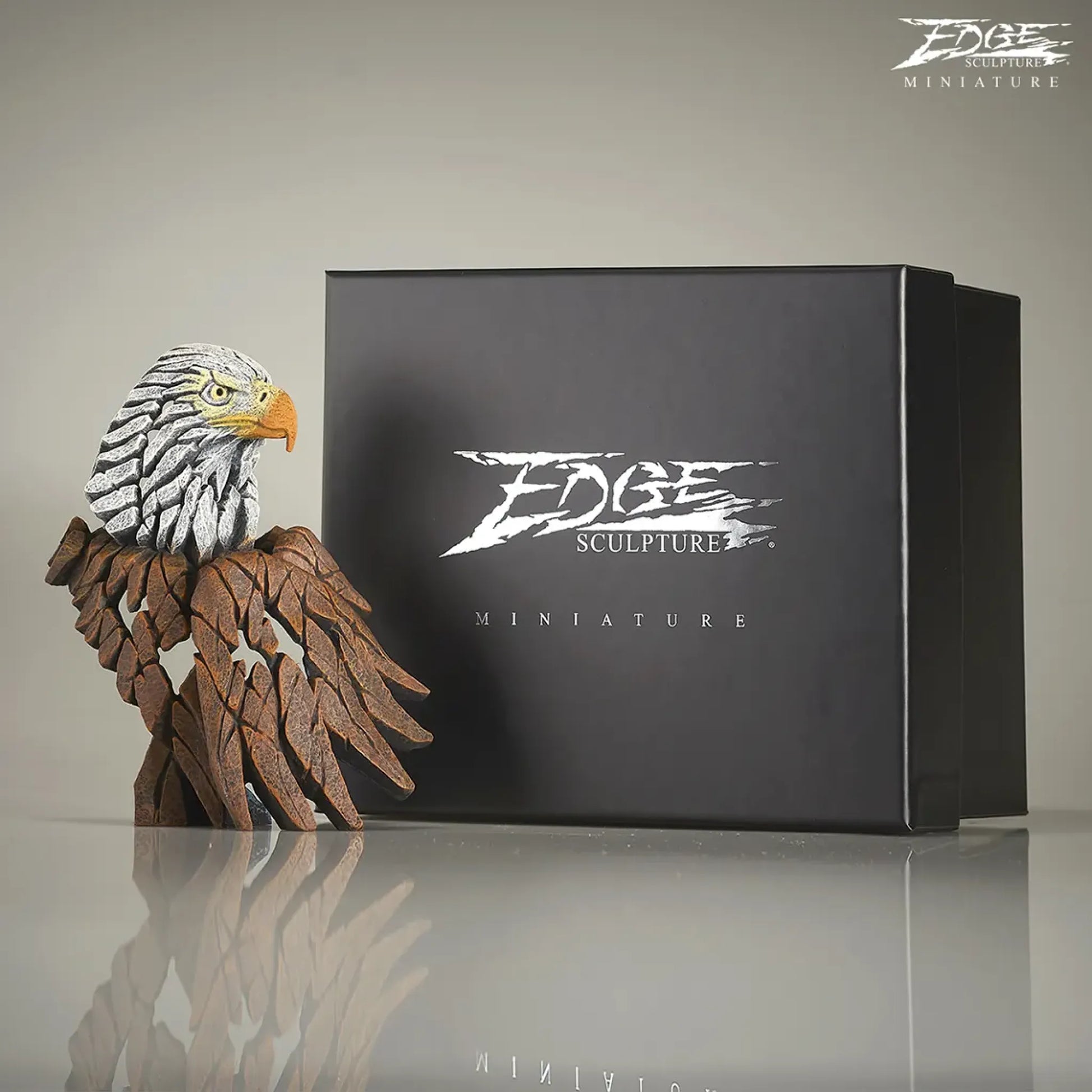 Brown and white painted American Eagle bust and wing sculpture next to packaging box