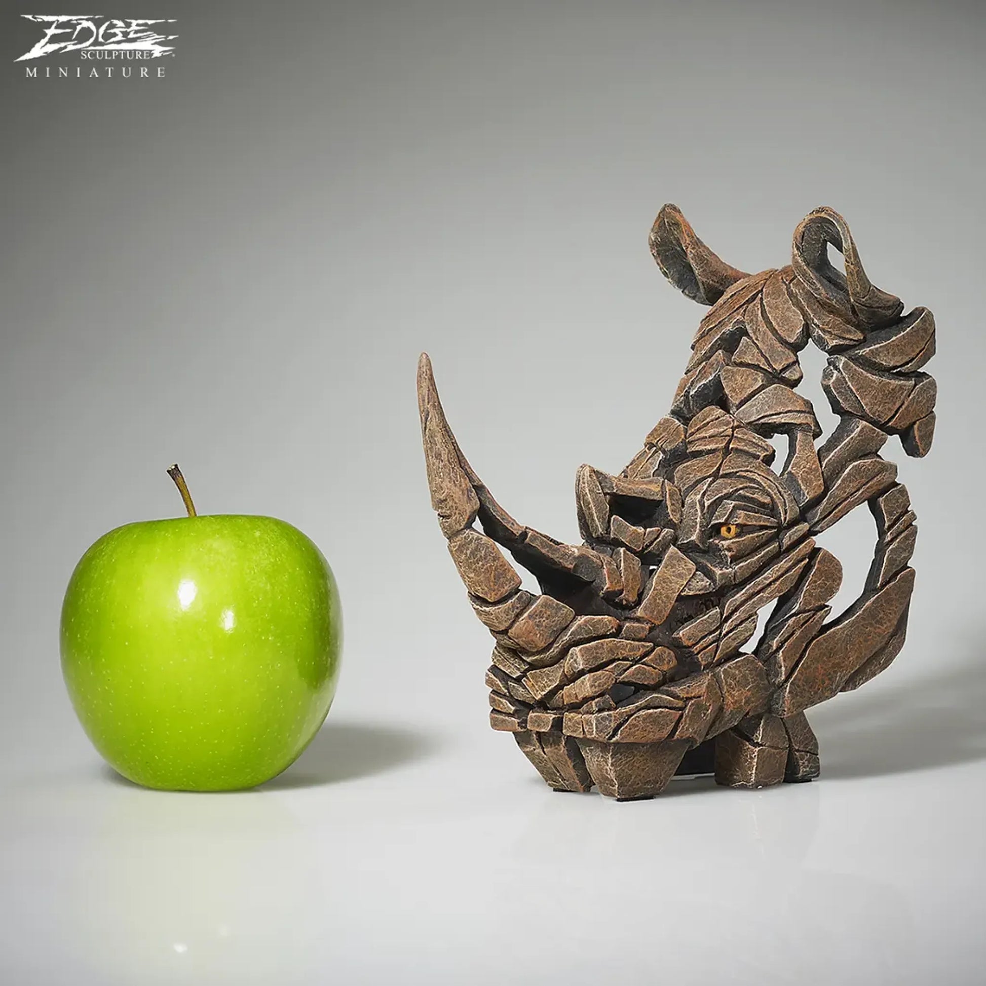 Rhinoceros bust sculpture in brown size comparison with apple