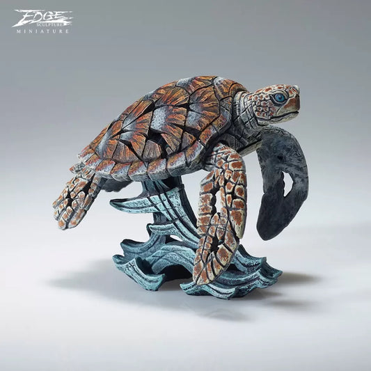 A textured and painted sea turtle surfing waves sculpture 