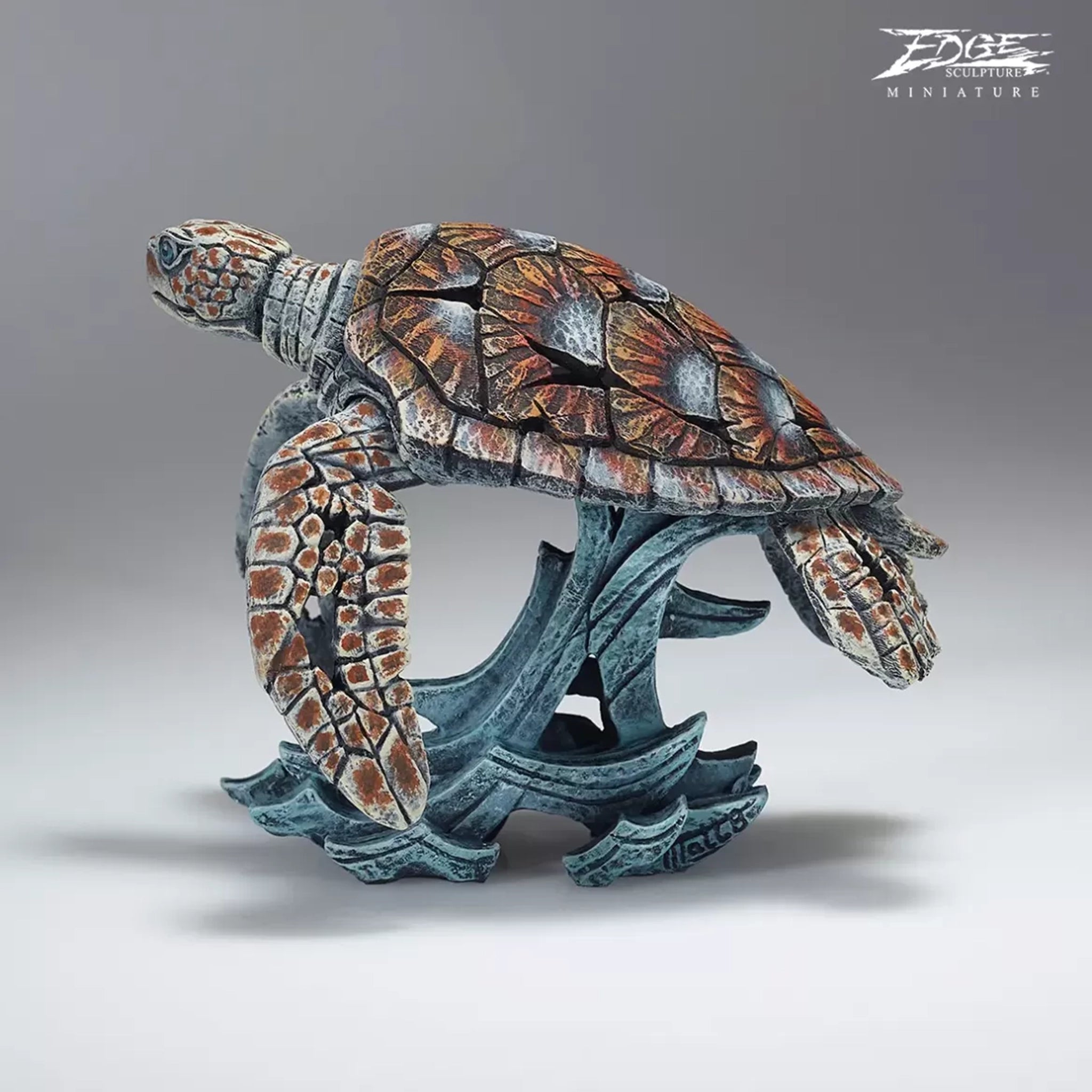 A textured and painted sea turtle surfing waves sculpture back view