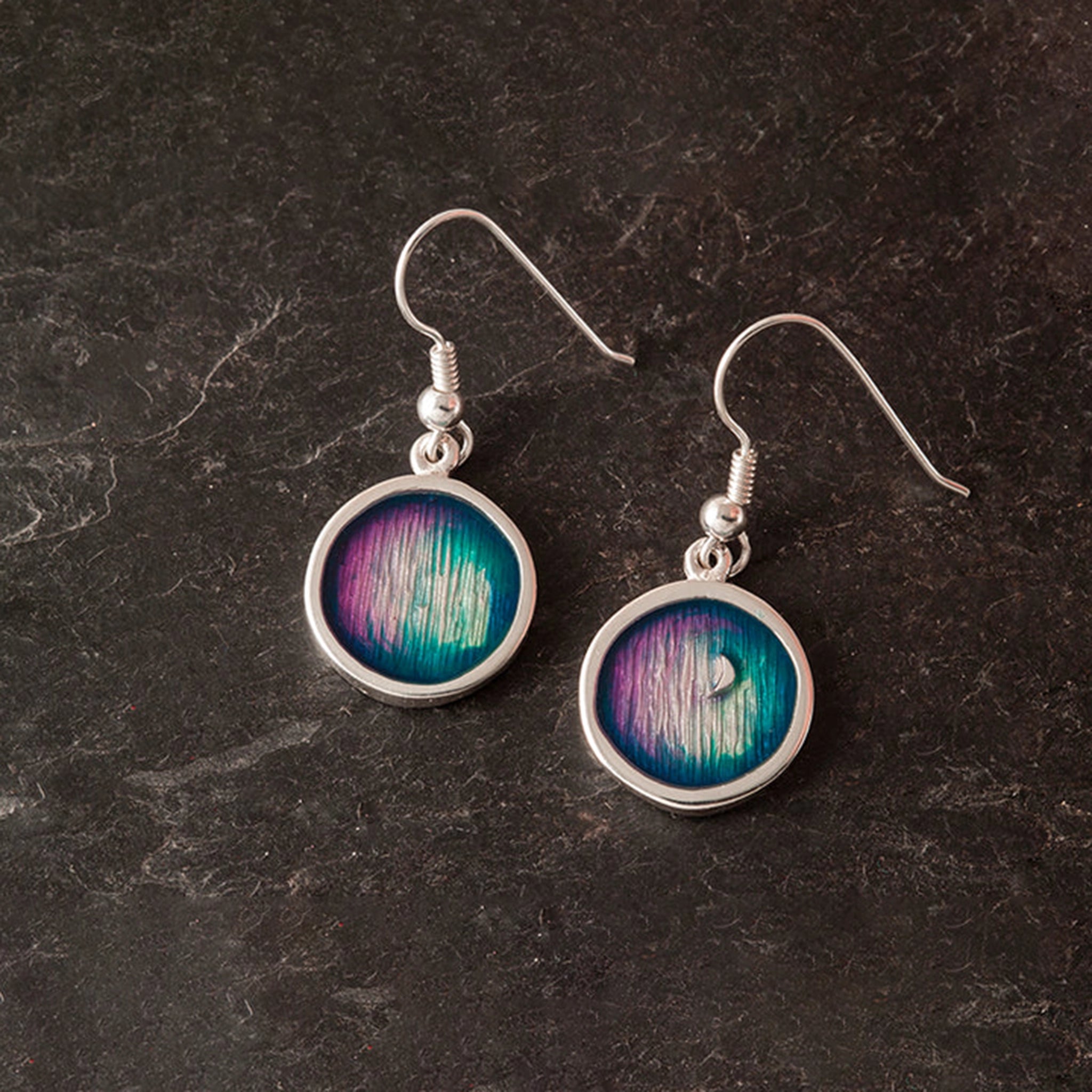 A pair of round drop earrings with blue and purple enamel in a round frame 