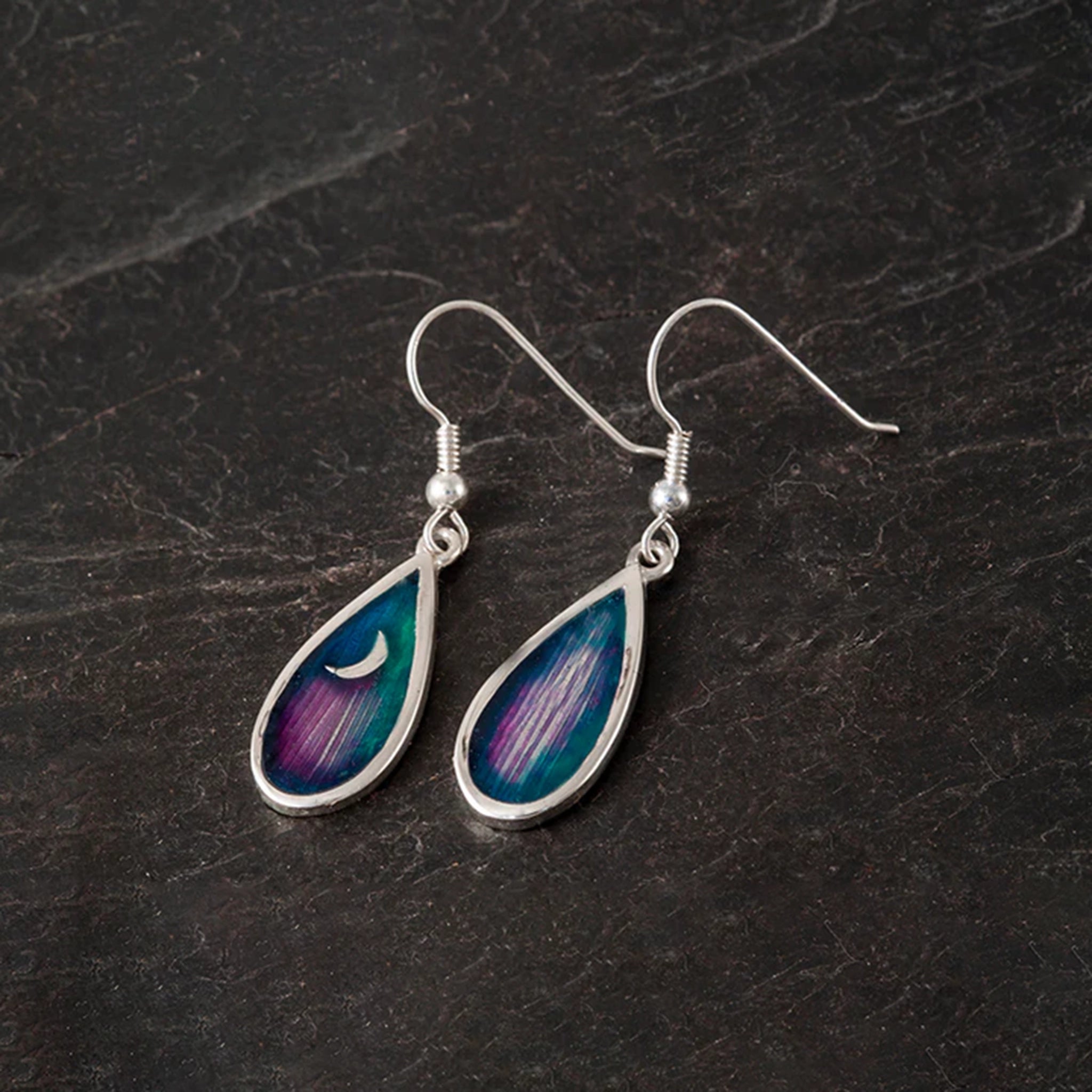 A pair of teardrop shaped earrings with silver frame and blue and purple enamel