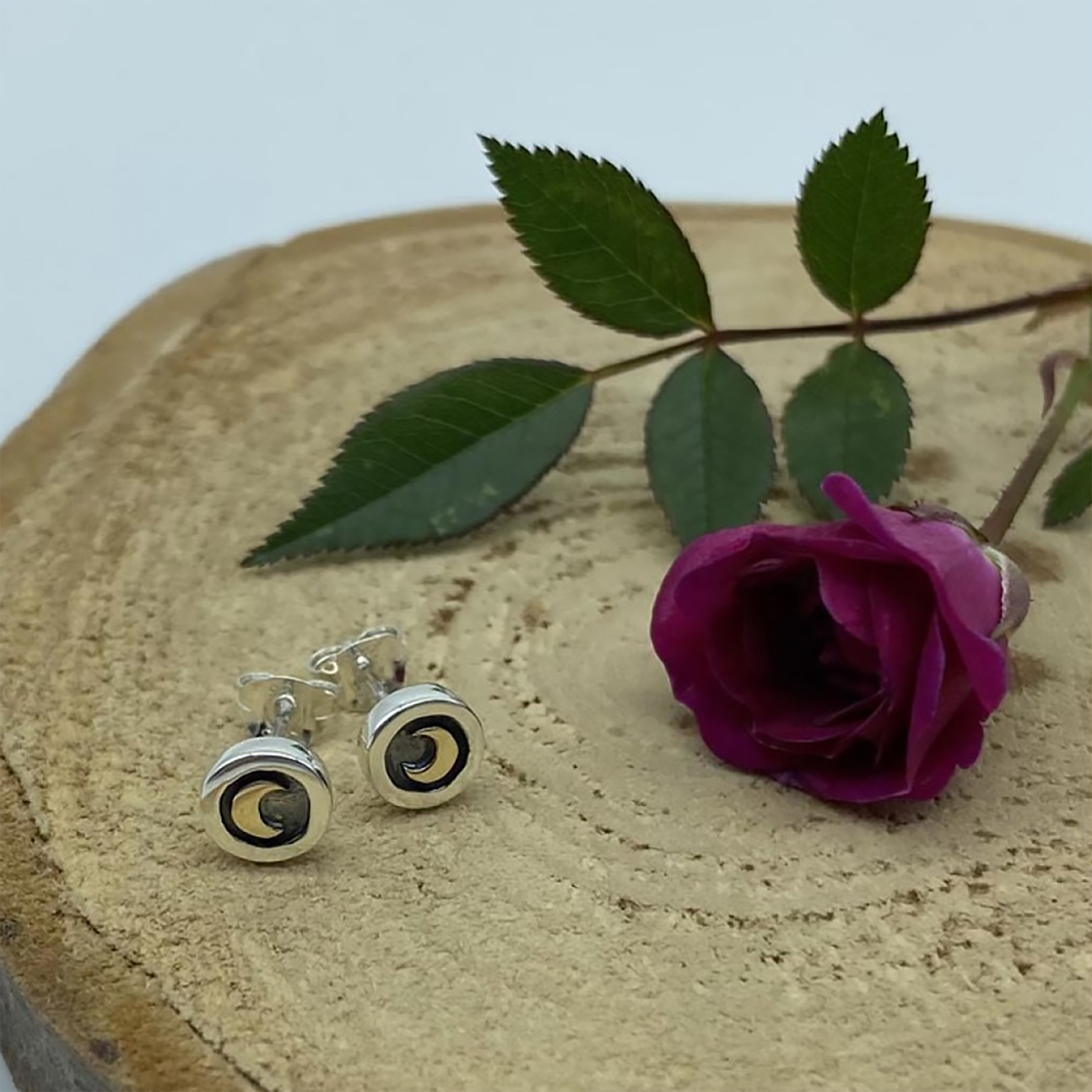 A pair of round silver frame stud earrings with oxidised detail and yellow moons lifestyle