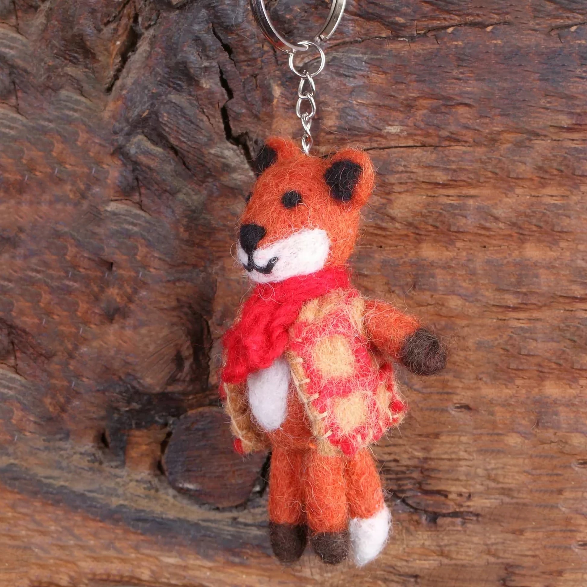 A felted fox keyring wearing a checked waistcoat and a red scarf