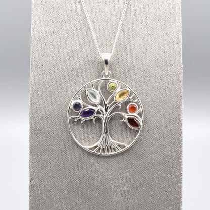 A round silver tree of life pendant with multicoloured gemstones for leaves