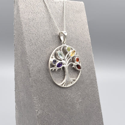 A round silver tree of life pendant with multicoloured gemstones for leaves side