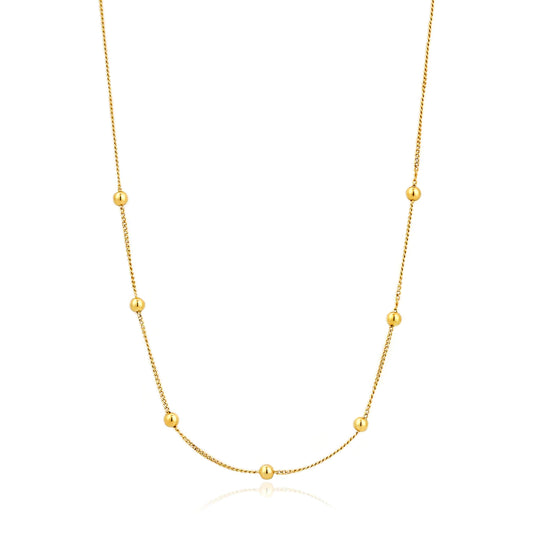 A gold chain necklae featuring 7 gold ball details spaced symmetrically