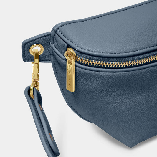 Close-up of gold hardware on navy blue faux leather belt bag