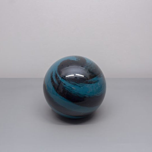 A round glass orb lamp designed based on the planet Neptune in swirls of lights and dark blue turned off
