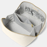 An off-white makeup and wash bag with a gold zip in faux leather fully open and lined in grey