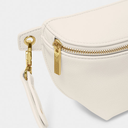 Close-up of gold hardware on off-white faux leather belt bag