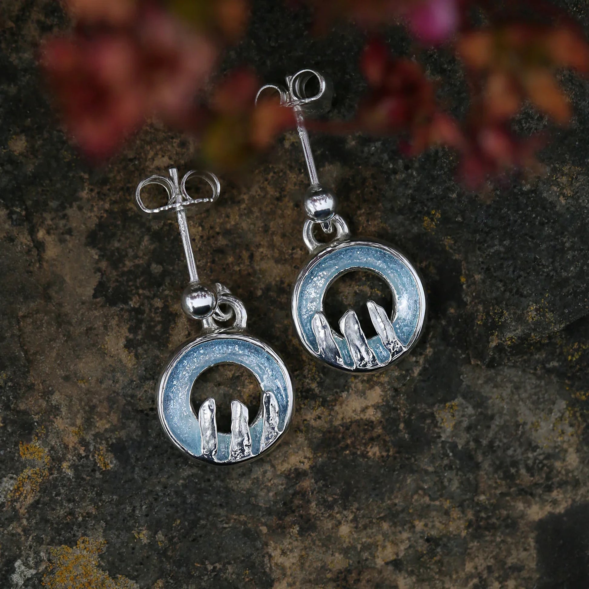 Silver drop earrings with round open circles in blue grey enamel, finished with a standing stone design - lifestyle