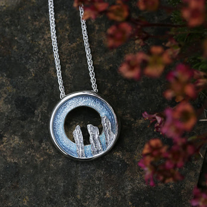 Silver open circle pendant with blue grey enamel and standing stone design on silver chain - lifestyle