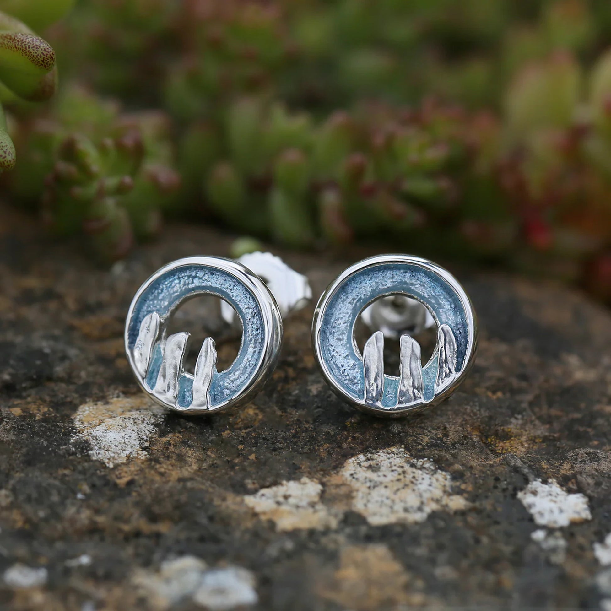 Round silver stud earrings with centre cutout, blue grey enamel, and standing stone details - lifestyle