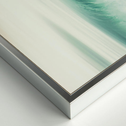 Detail view of chrome frame for art print featuring an ocean wave in a calm blue gradient