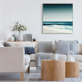 A large square art print featuring an ocean wave in a calm blue gradient on wall