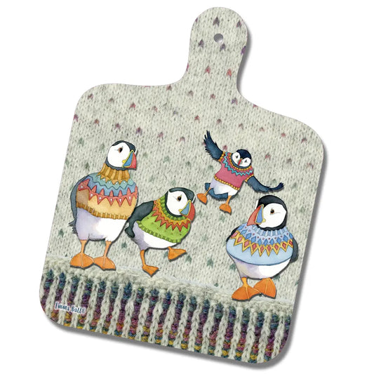 A paddle shaped chopping board with a design of puffins wearing woolly jumpers