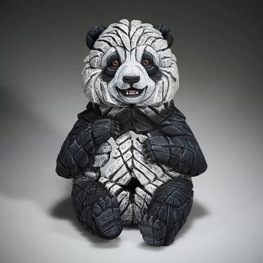 A textured and painted sitting panda cub figure sculpture