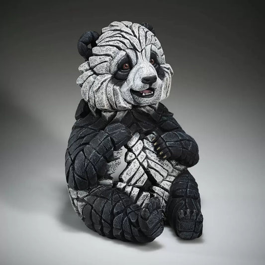 A textured and painted sitting panda cub figure sculpture side view