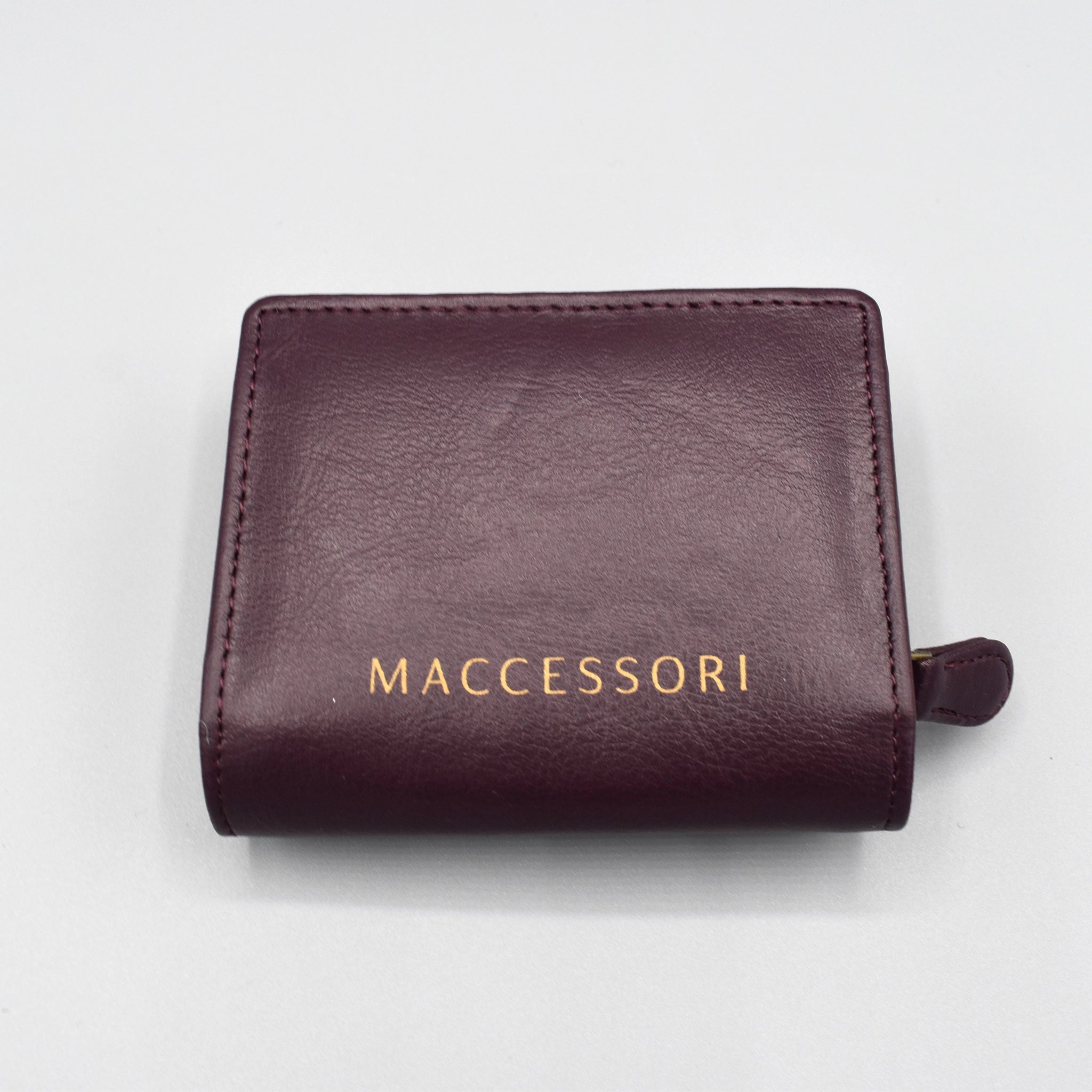 the back of a purple faux leather purse with the MACCESSORI logo in gold