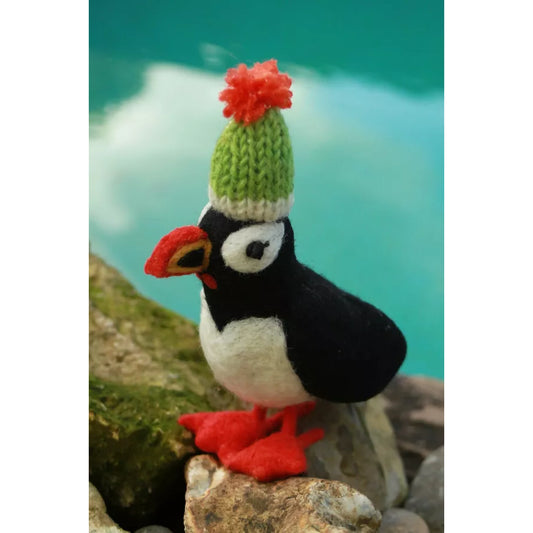 A felted puffin in a green knitted hat with orange pompom
