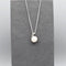 Small silver pendant with twist set with cubic zirconia stones and a round white fresh water pearl