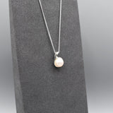 Small silver pendant with twist set with cubic zirconia stones and a round white fresh water pearl