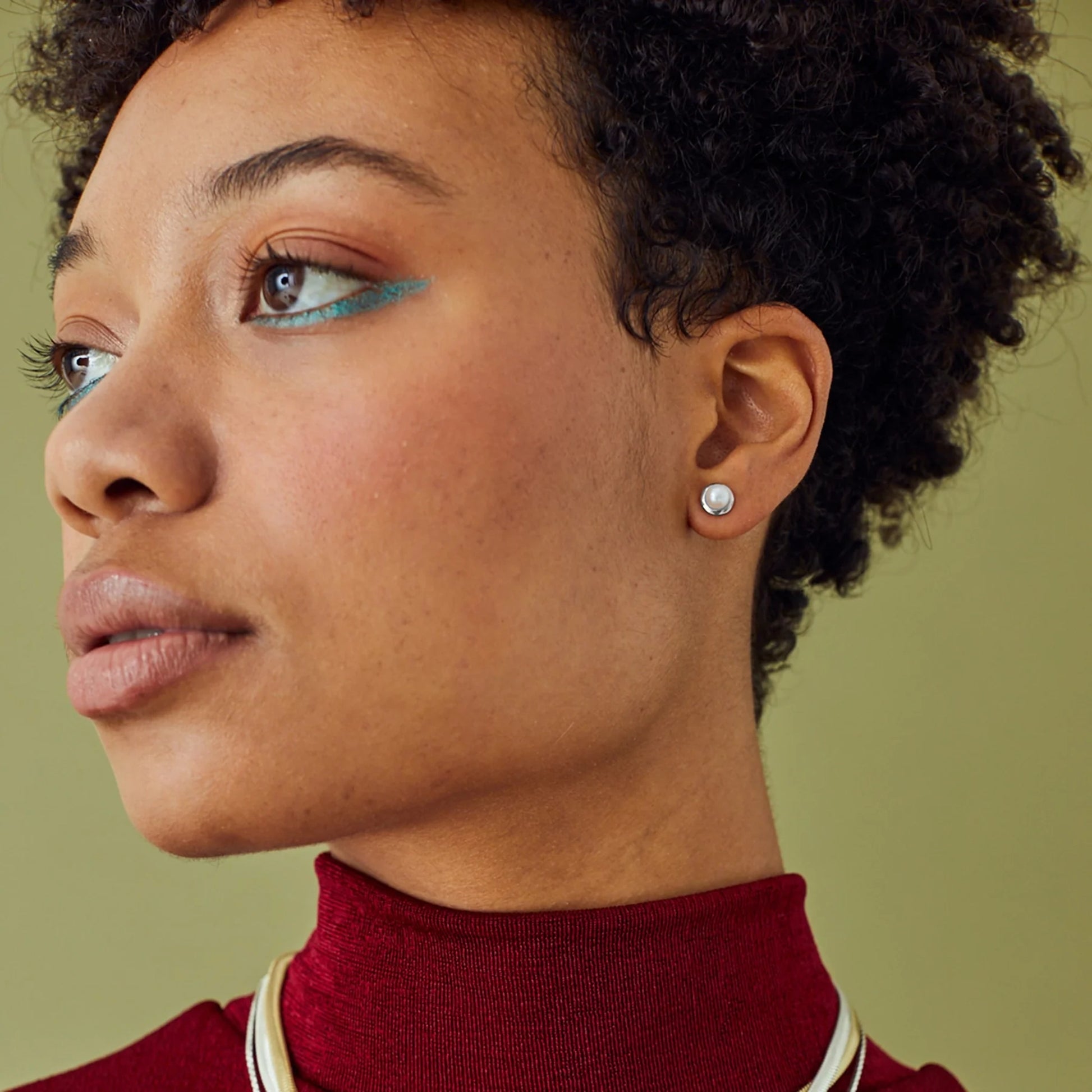 Model wearing silver round stud earrings with white freshwater pearls