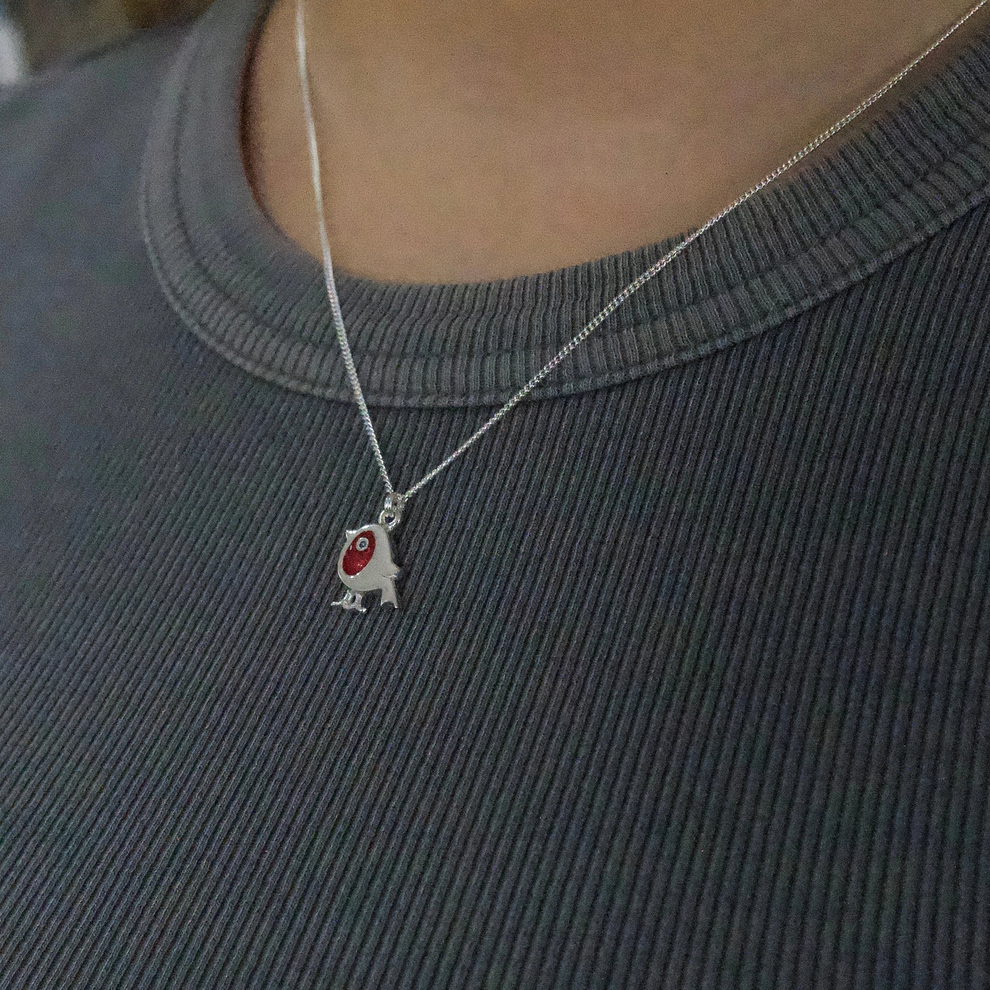 Model wearing a silver pendant with red enamel robin on silver chain