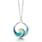 A silver pendant in the shape of an ocean wave coloured with blue and green enamel