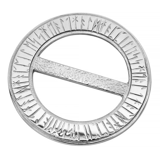 A large round pewter brooch with hammered details and engraved runic writing