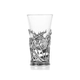 A shot glass with pewter base featuring a stag head with trinity knots and thistles