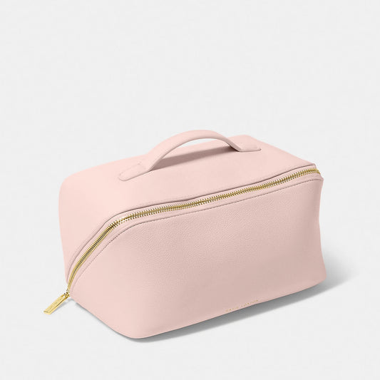A pink makeup and wash bag with a gold zip in faux leather