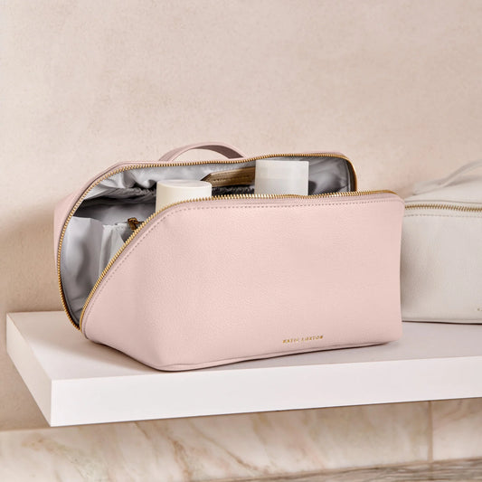 A pink makeup and wash bag with a gold zip in faux leather lifestyle