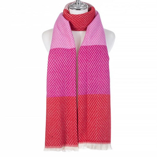 A chevron scarf with colour block pattern in pink and red and a white tassel trim