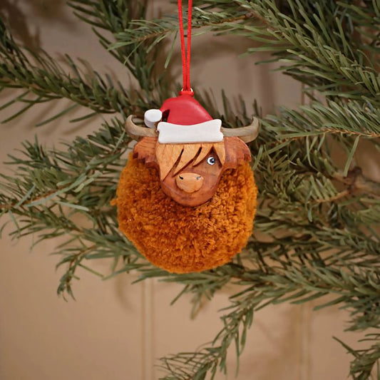 Hanging Christmas ornament of a pompom Highland cow in a Santa hat