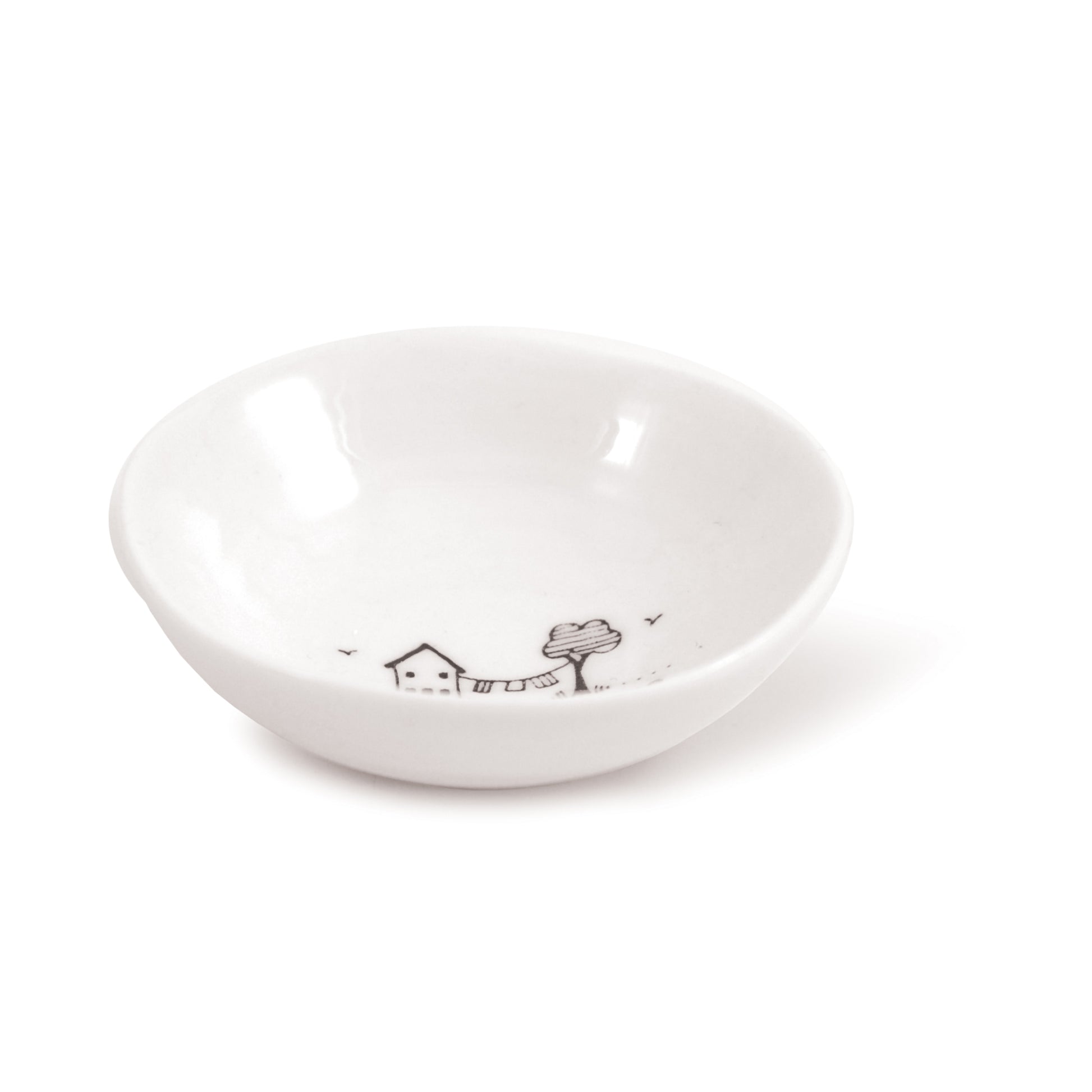 A white ceramic trinket bowl featuring a house & tree illustration and a quote side
