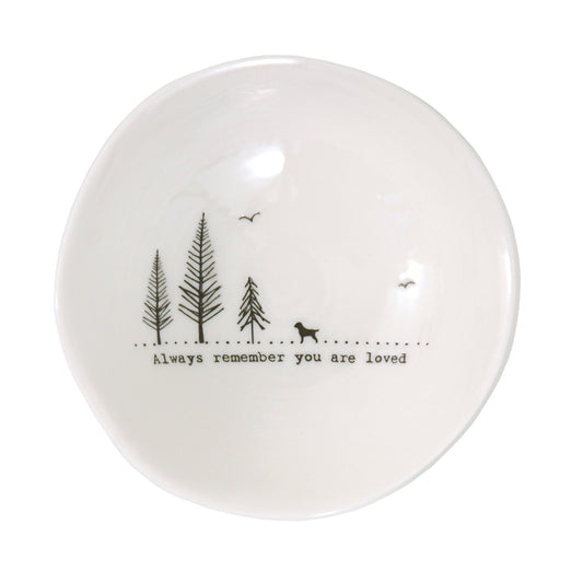 A white ceramic bowl featuring a dog illustration and a quote
