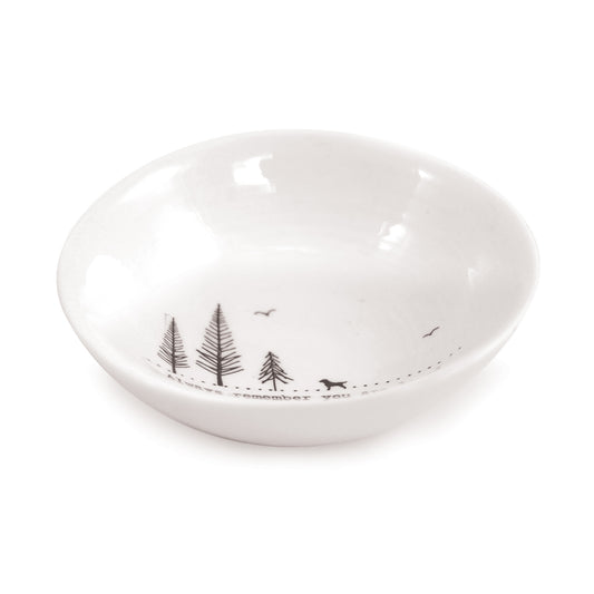 A white ceramic bowl featuring a dog illustration and a quote side