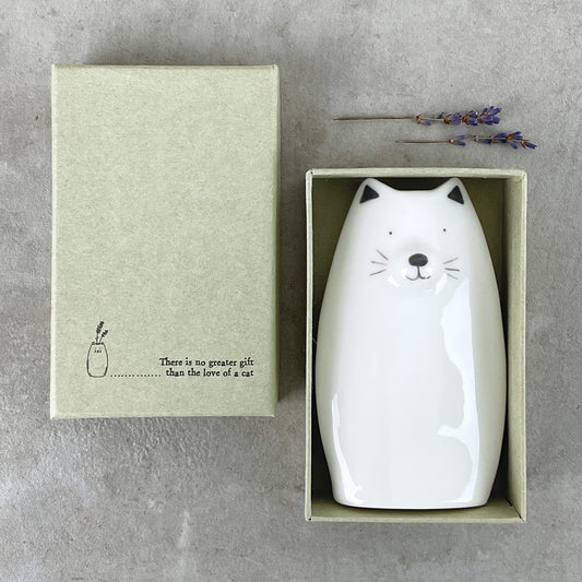 A minimalist white vase shaped like a cat in a box