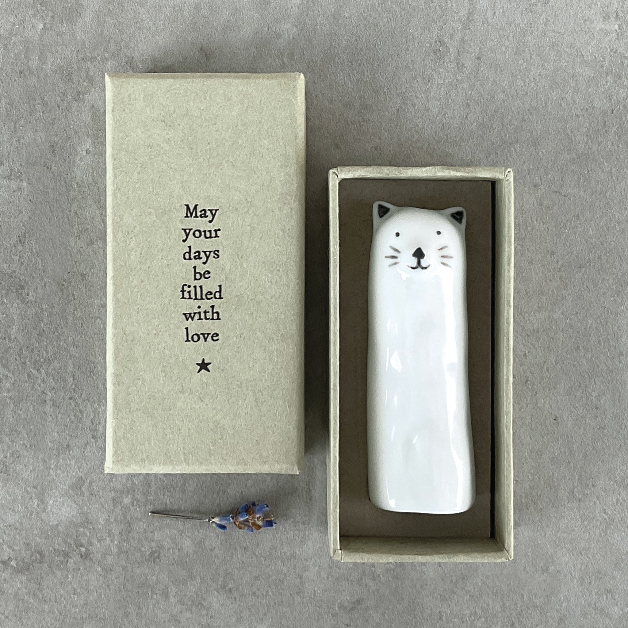 A slim modern minimalist vase shaped like a cat in a box