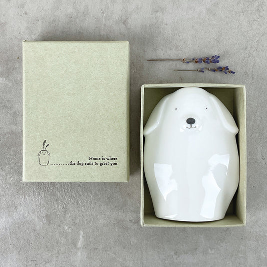 A minimalist white vase shaped like a dog in a box