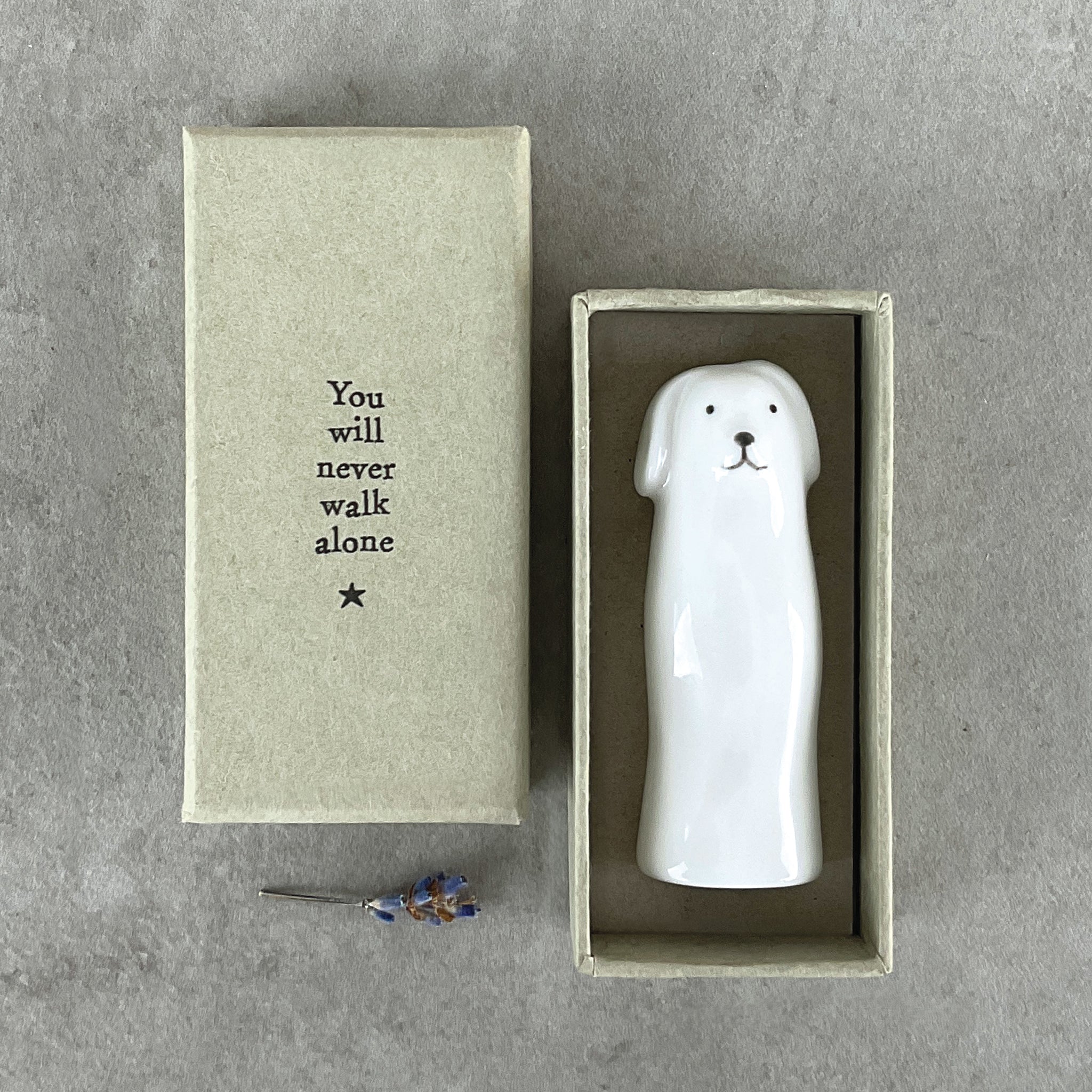 A slim modern minimalist vase shaped like a dog holding in a box