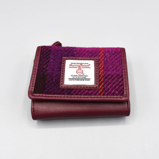 A purple faux leather purse with genuine check Harris Tweed in the front