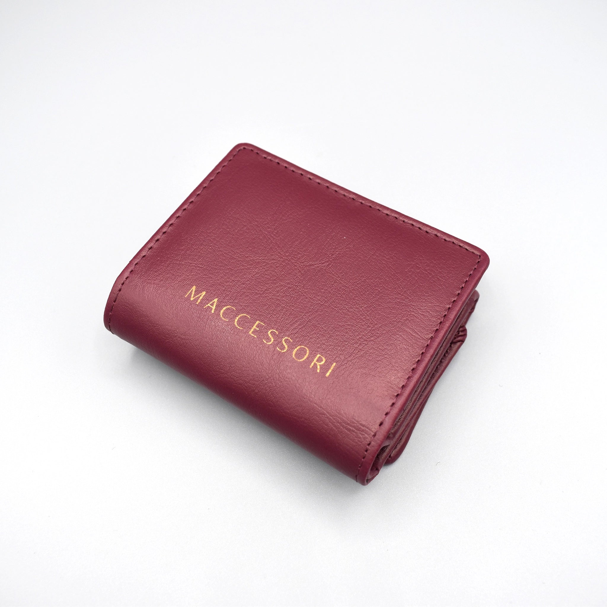 the back of a purple faux leather purse with the MACCESSORI logo in gold